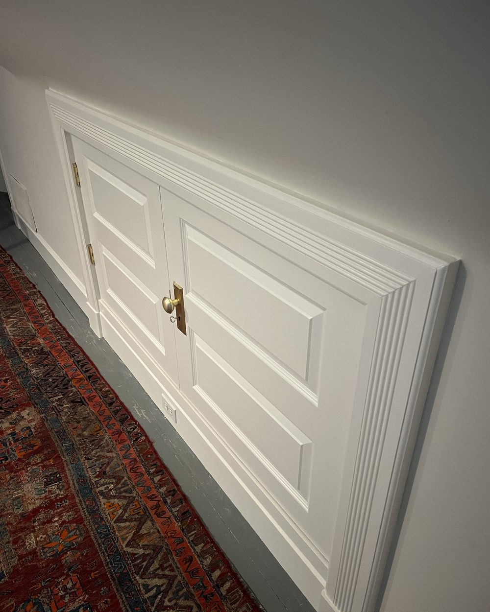 Finished white paneled knee-wall storage doors