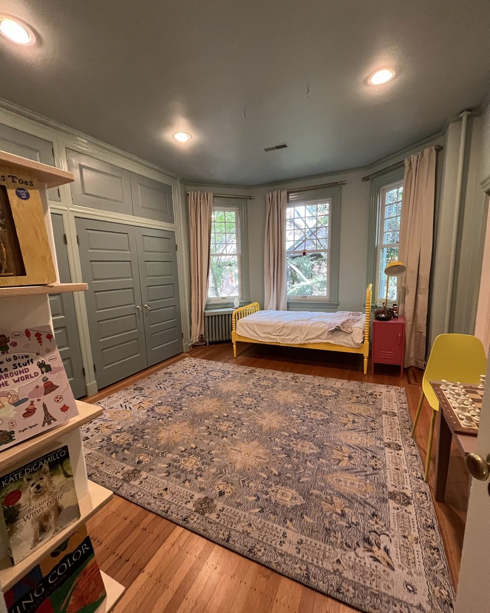 Bedroom with built-in paneled closet wall and window seat