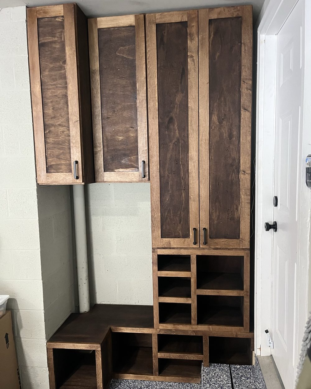 Custom mudroom with walnut-toned lockers, bench and cubbies
