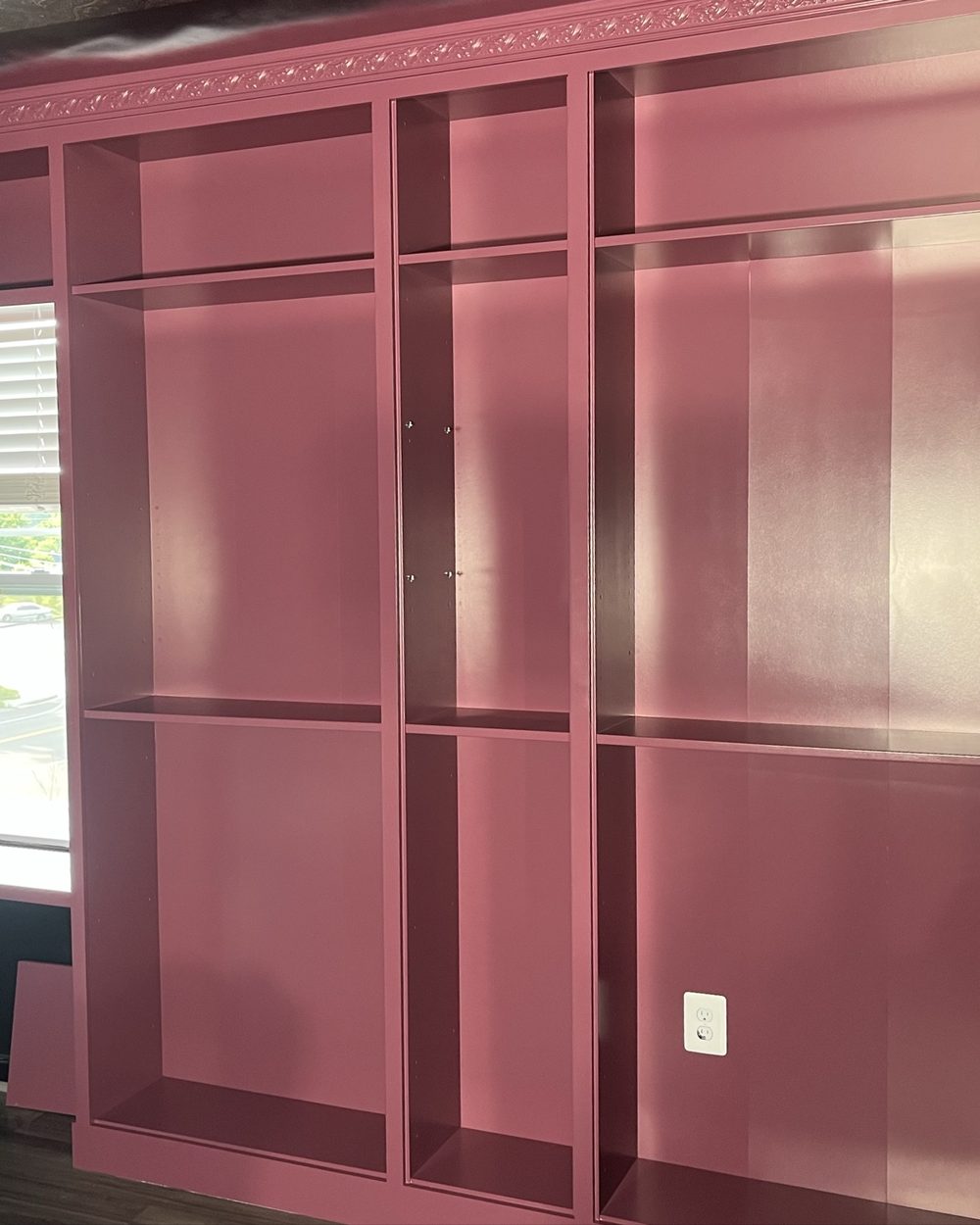 Deep red board and batten paneling built around a window