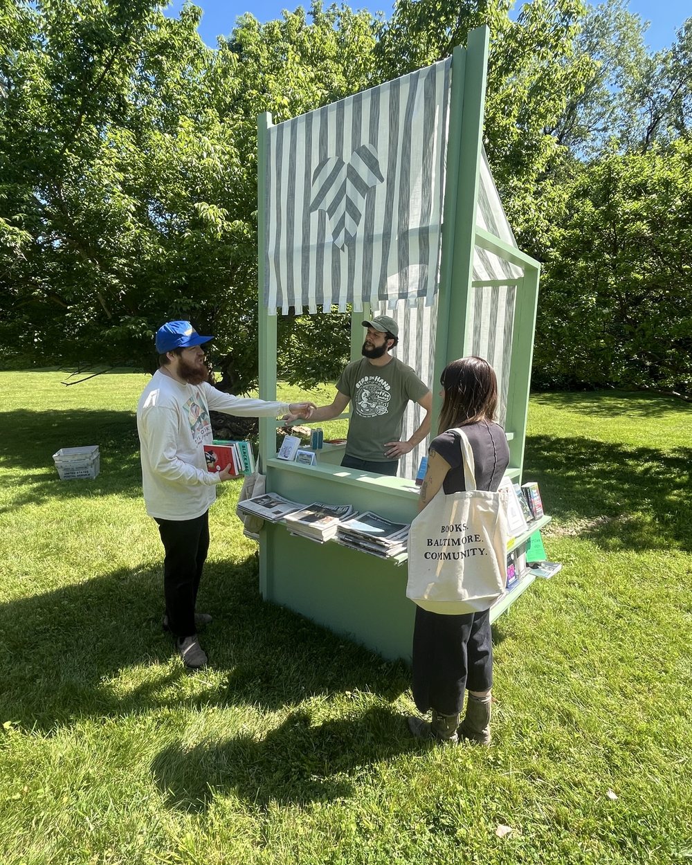 The finished mint green book kiosk in use at a park in Baltimore