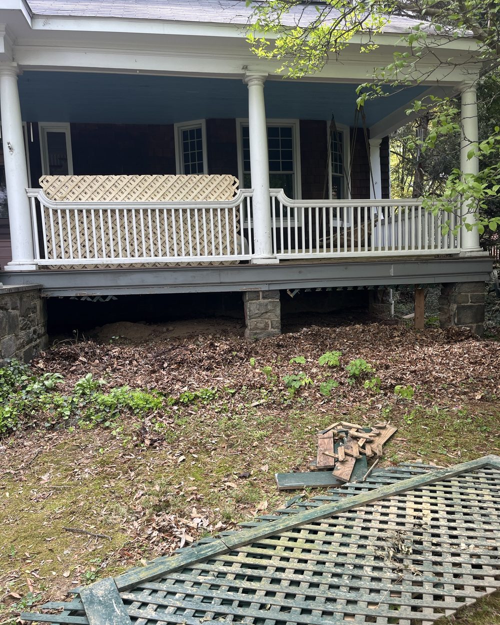 Front porch with failing lattice and bare ground
