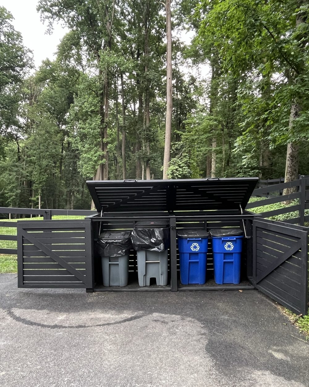 Black slat enclosure with the lids open showing bins inside