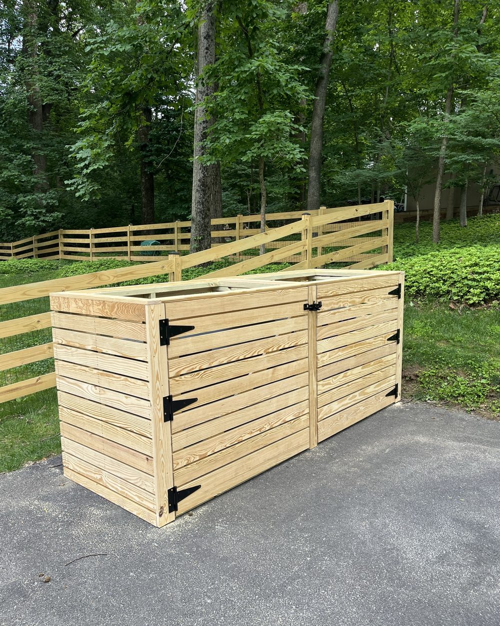 Newly built cedar trash bin enclosure in natural wood