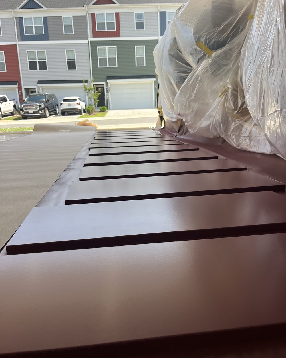 Dark stained panels laid out to cure outdoors