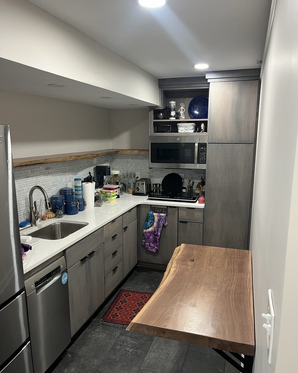 The walnut live-edge table folded down in a narrow galley kitchen