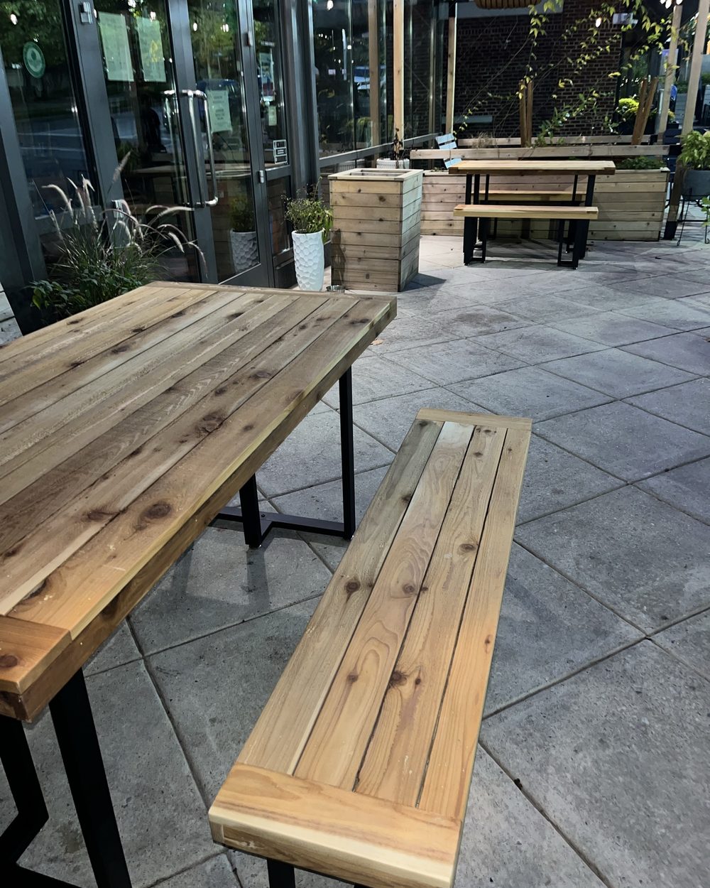 Custom outdoor wood dining table with matching bench on a patio