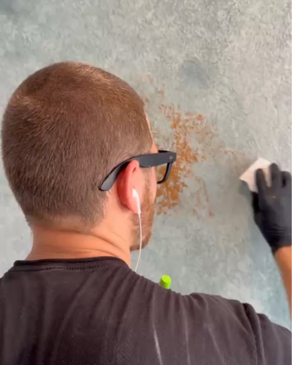 Craftsman burnishing a blue-grey Venetian plaster wall with a cloth