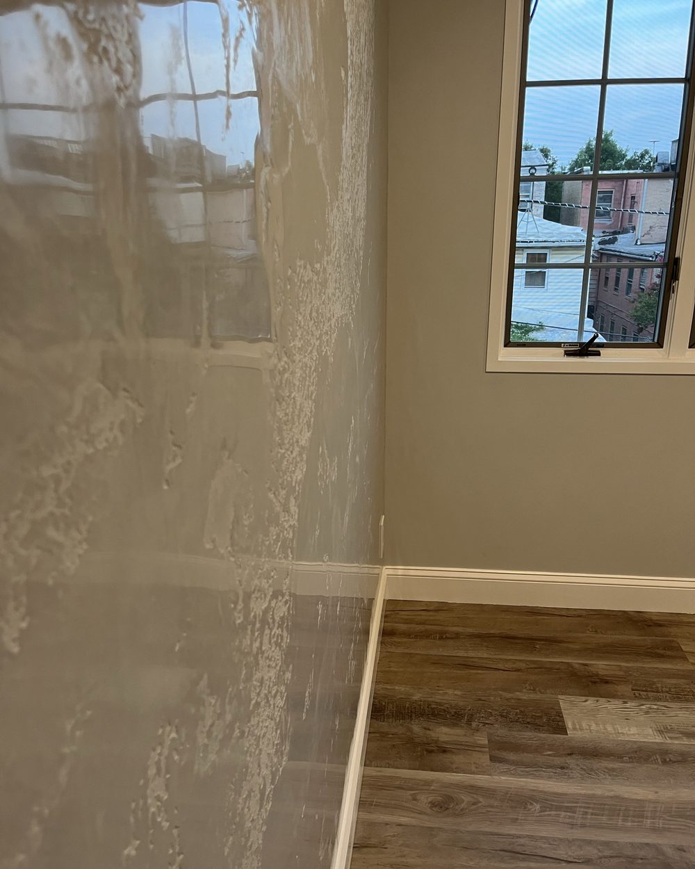 Freshly applied plaster skim coat drying on a wall