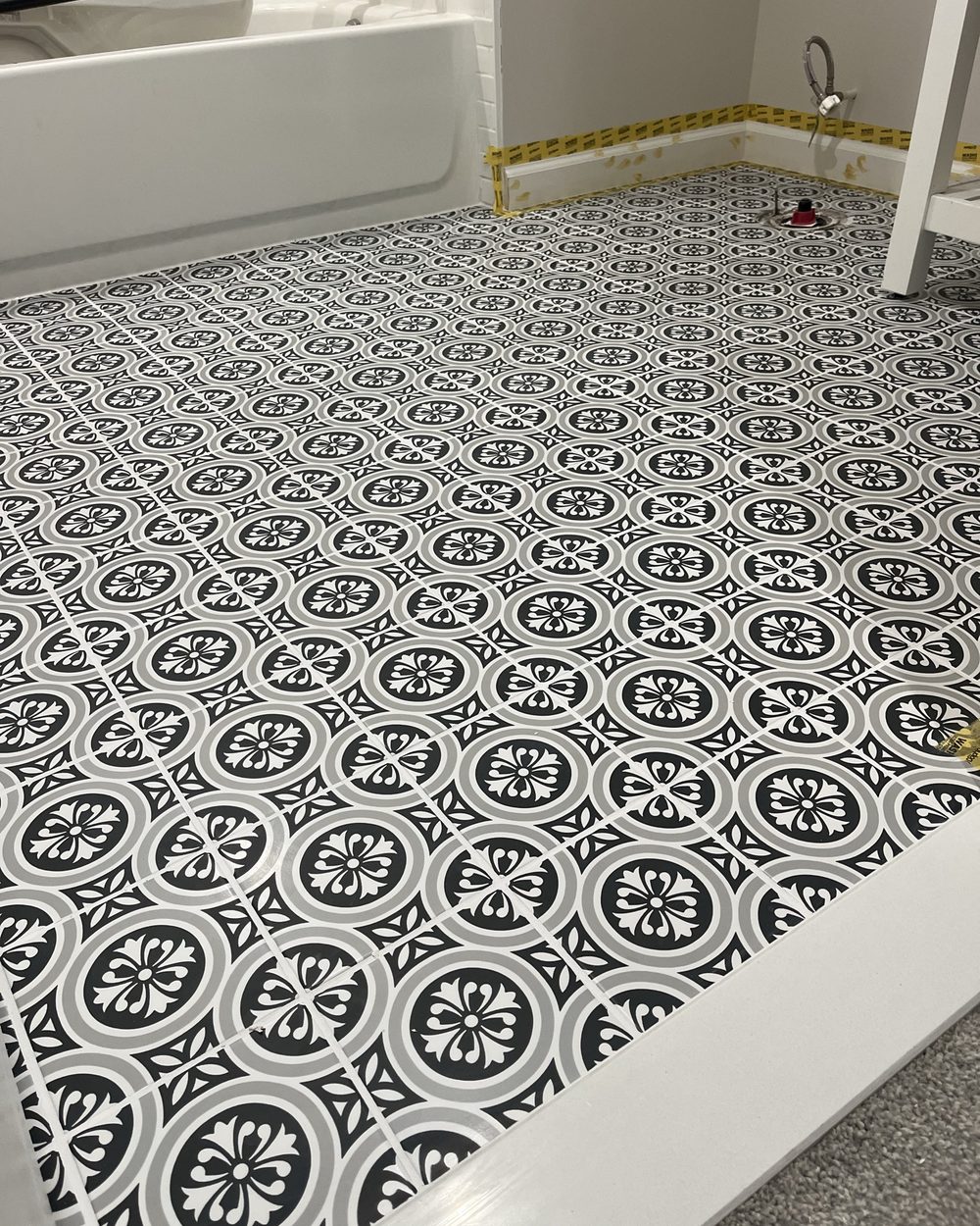Black and white patterned encaustic tile floor freshly laid