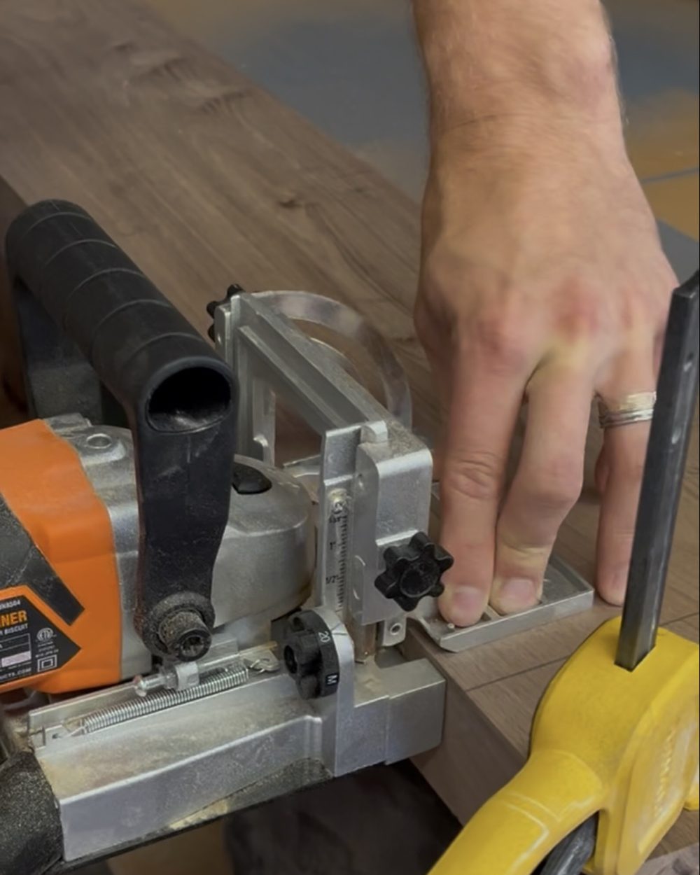 Hands guiding molding through a miter saw