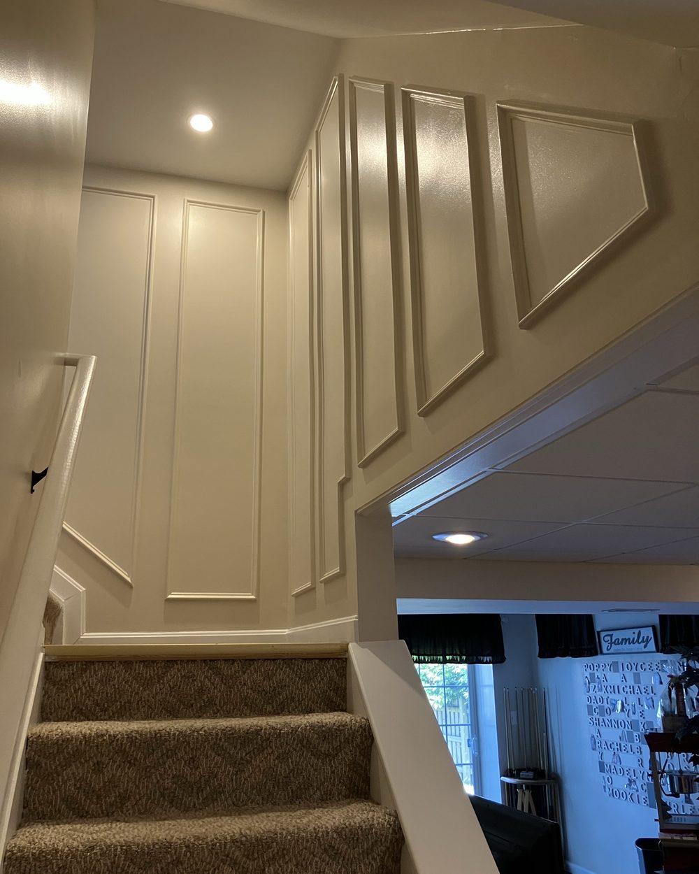 Stairway wall with custom picture-frame wainscoting panels
