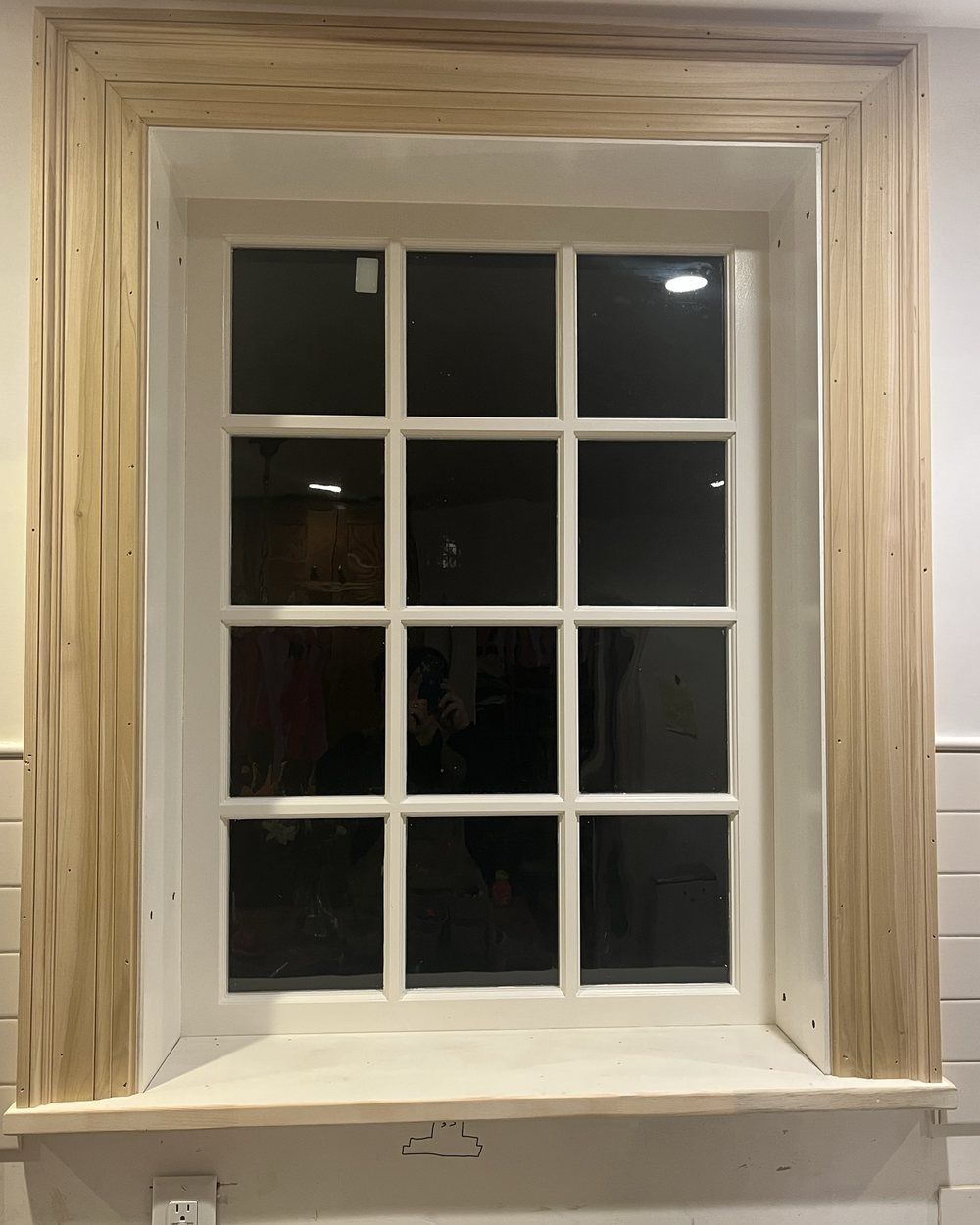 New poplar window casing and stool installed around a divided-light window